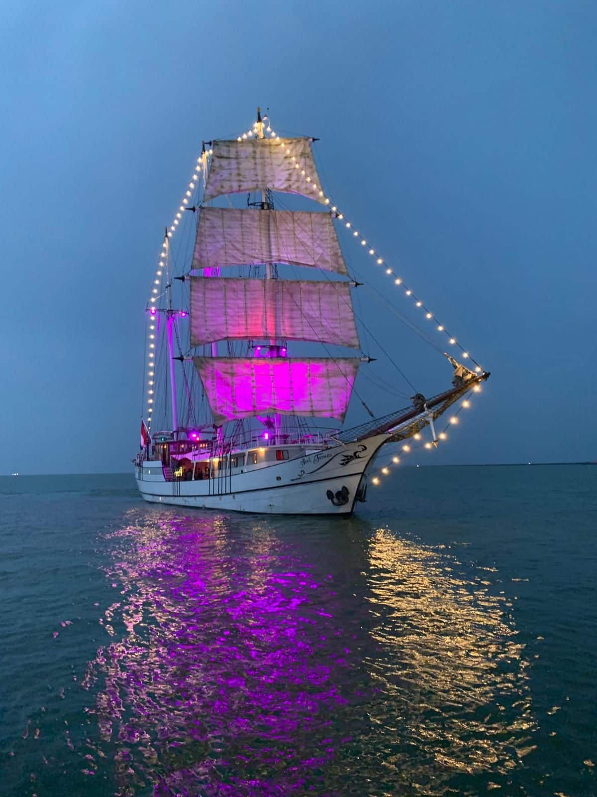 Het schip bij schemering met lichtjes in de tuigage.